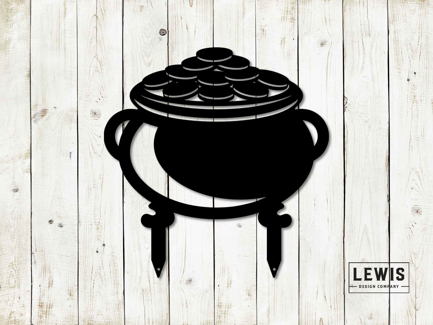 Black metal pot of gold yard stake silhouette with gold coins inside, designed for St. Patrick's Day, against a wooden background.