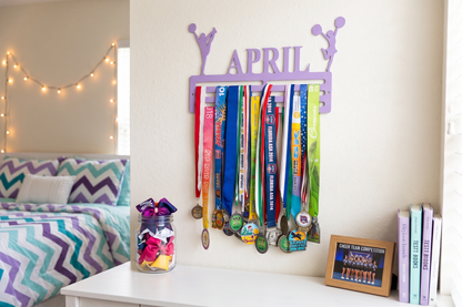 Decorative display with colorful ribbons, a jar of flowers, and books on a shelf. Cheerleader Medal and Award Hanger.  Cheer Award Display