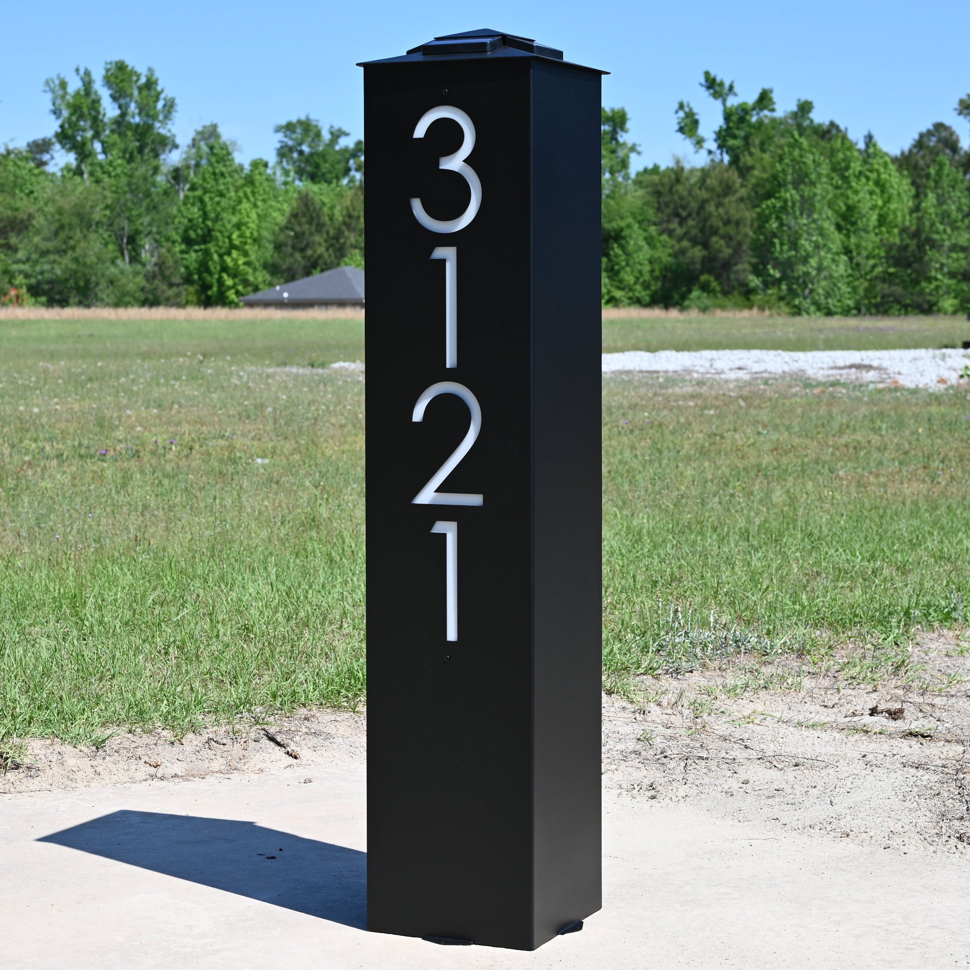 Black post with white numbers in an open field