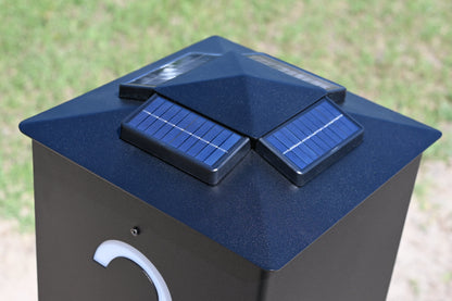 Black solar-powered device with two solar panels on a grassy background