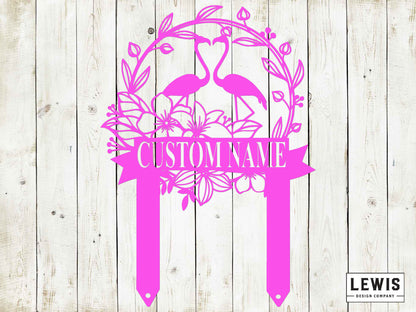 Pink decorative sign with flamingo design and 'Custom Name' text on a wooden background, featuring the Lewis Design Company logo.