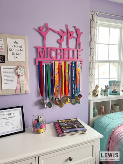 Pink medal holder with ribbons on a purple wall above a white dresser.