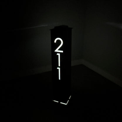 Lighted sign with the number '211' in a dark setting