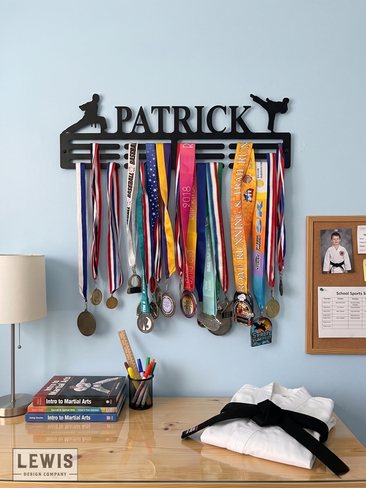 Karate Medal holder with medals on a wall above a desk with books and a lamp.