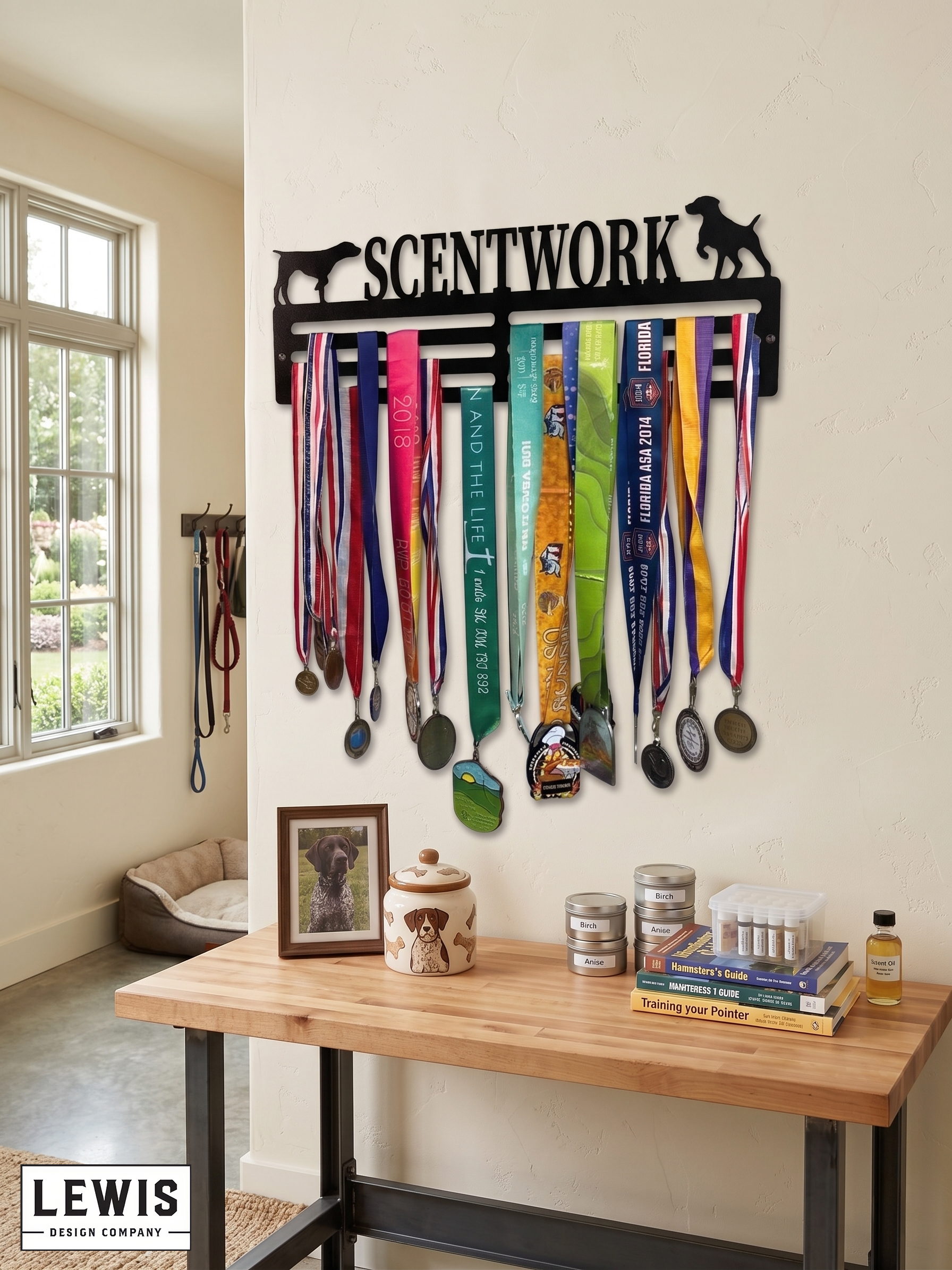 Medal holder with medals and dog accessories on a wall in a room with a desk and window. Dog medal holder with ribbons