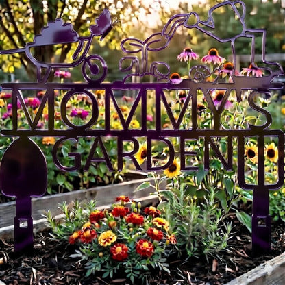 Decorative metal sign reading 'Mommy's Garden' in a garden setting with flowers and plants.