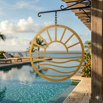 Gold Sun and Waves metal wall art hanging poolside at beach house with palm trees and ocean backdrop
