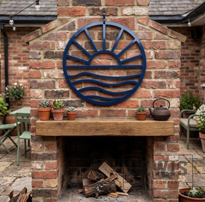 Navy blue Sun and Waves metal wall art mounted above brick outdoor fireplace for patio and backyard decor