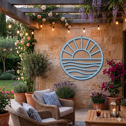Pastel blue Sun and Waves metal wall art on stone patio with wicker seating for cozy outdoor coastal decor
